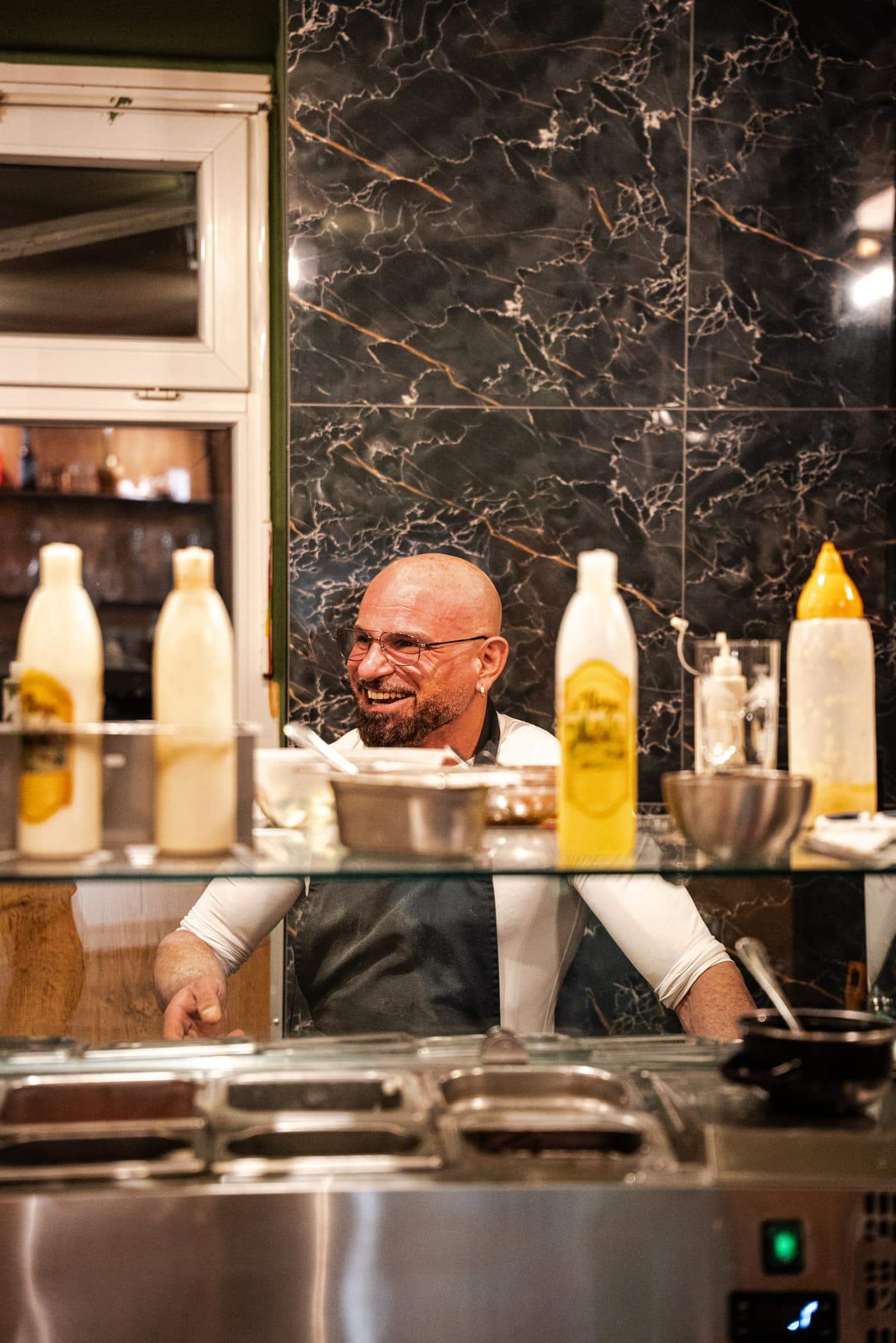 Francesco Ialazzo lacht hinter der Theke der Pizzeria Capri